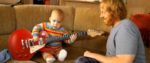 Baby spielt Rocklied auf Gitarre